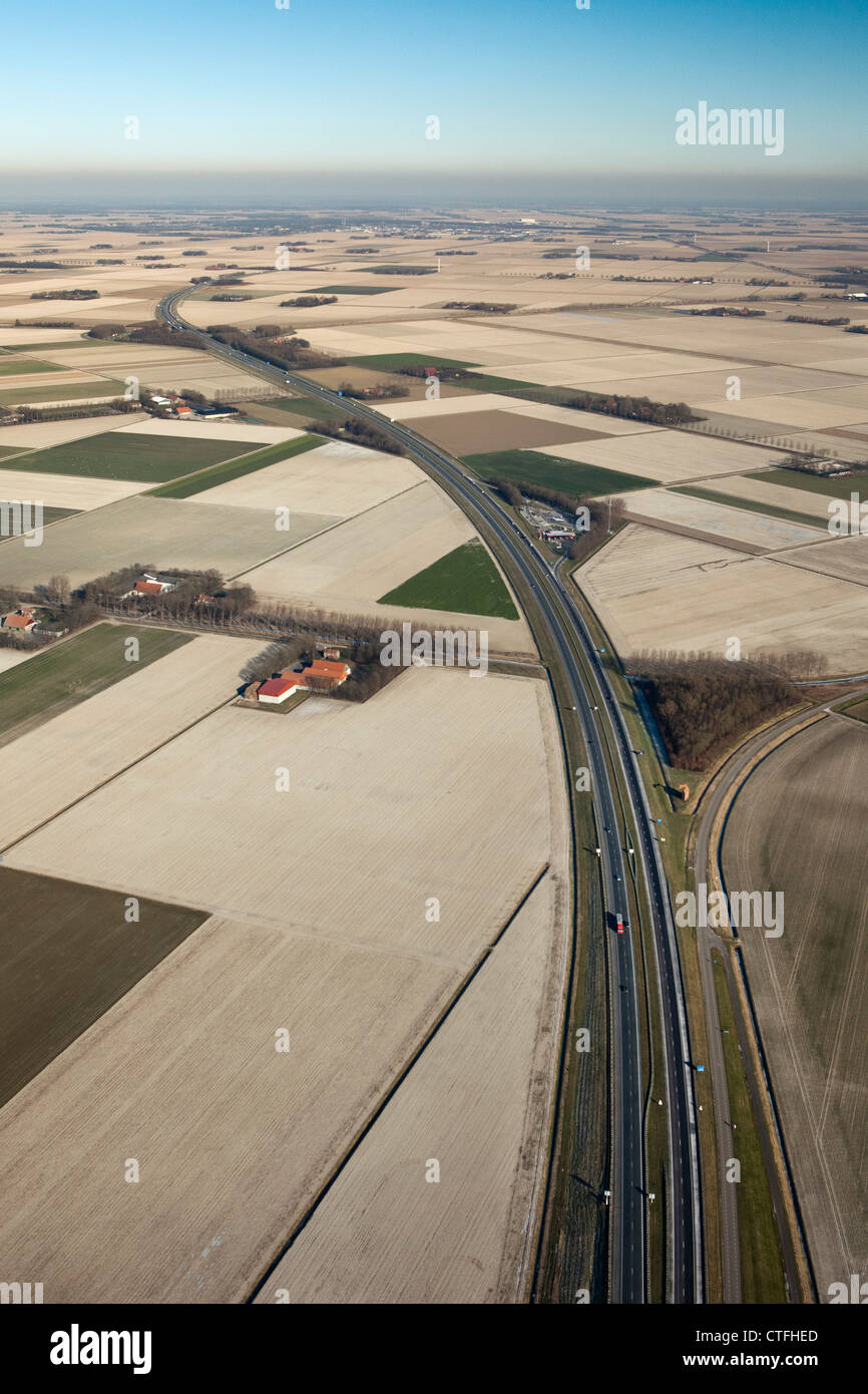 Die Niederlande, Nagele, Farmen und Ackerland in Flevopolder. Auf der Autobahn A6. Antenne. Stockfoto