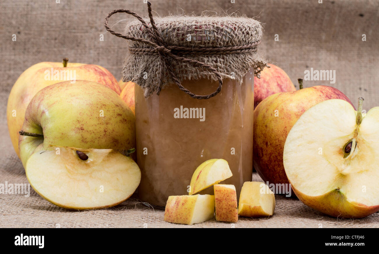 Frische hausgemachte Apfelmus mit rohen Äpfeln auf einem Textil-Hintergrund Stockfoto