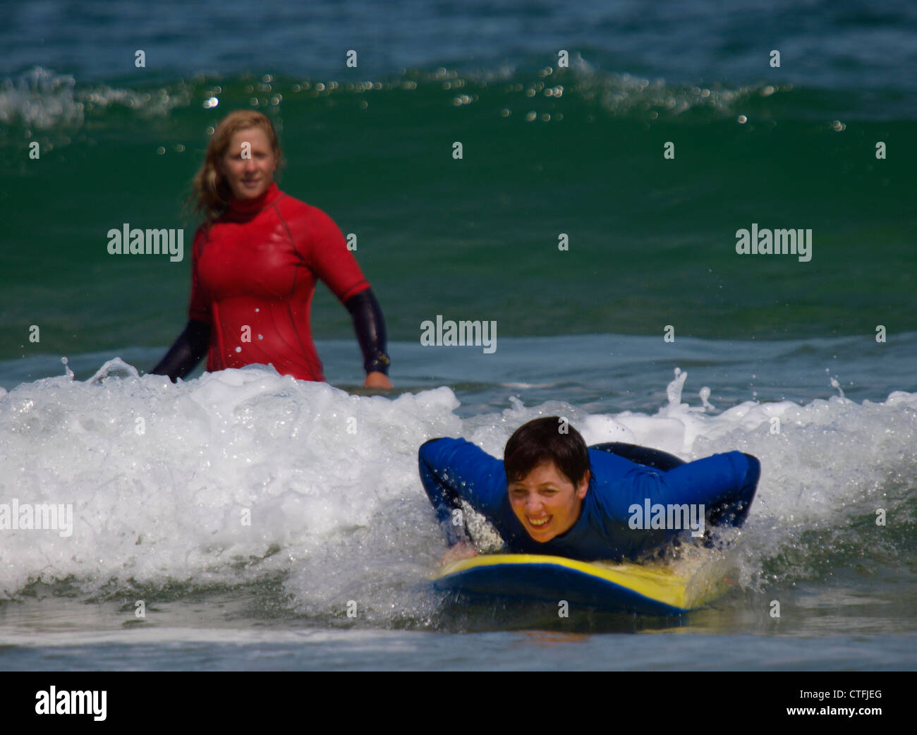 Frau lernen Surfen mit Instruktor, Newquay, Cornwall, UK Stockfoto