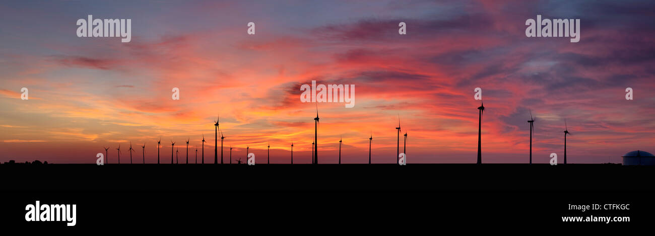 Emsmündung, Eemshaven, Windkraftanlagen und traditionelle Windmühle. Sonnenuntergang. Panorama-Blick. Stockfoto