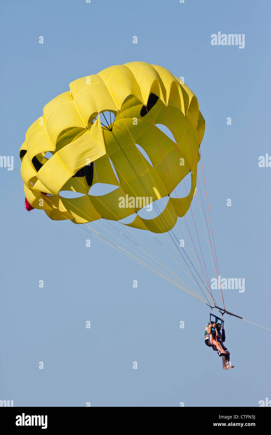 Paar parasailing mit einem blauen Himmelshintergrund in Pensacola Beach, Florida. Vertikales Bild. Stockfoto
