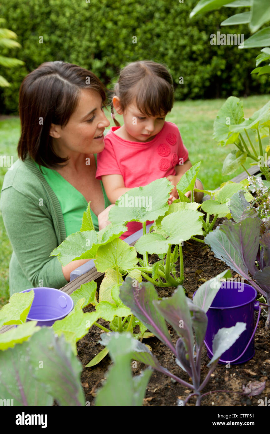 Mutter und Tochter suchen auf Pflanzen in einem Garten. Stockfoto
