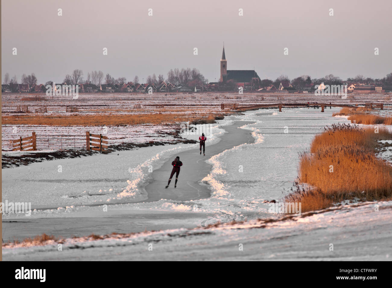 Niederlande, Schermerhorn, Winter, Eislaufen Menschen am Polder-Kanal. Stockfoto