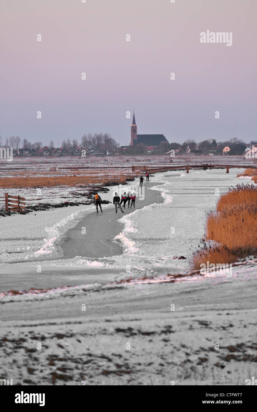 Niederlande, Schermerhorn, Winter, Eislaufen Menschen am Polder-Kanal. Stockfoto