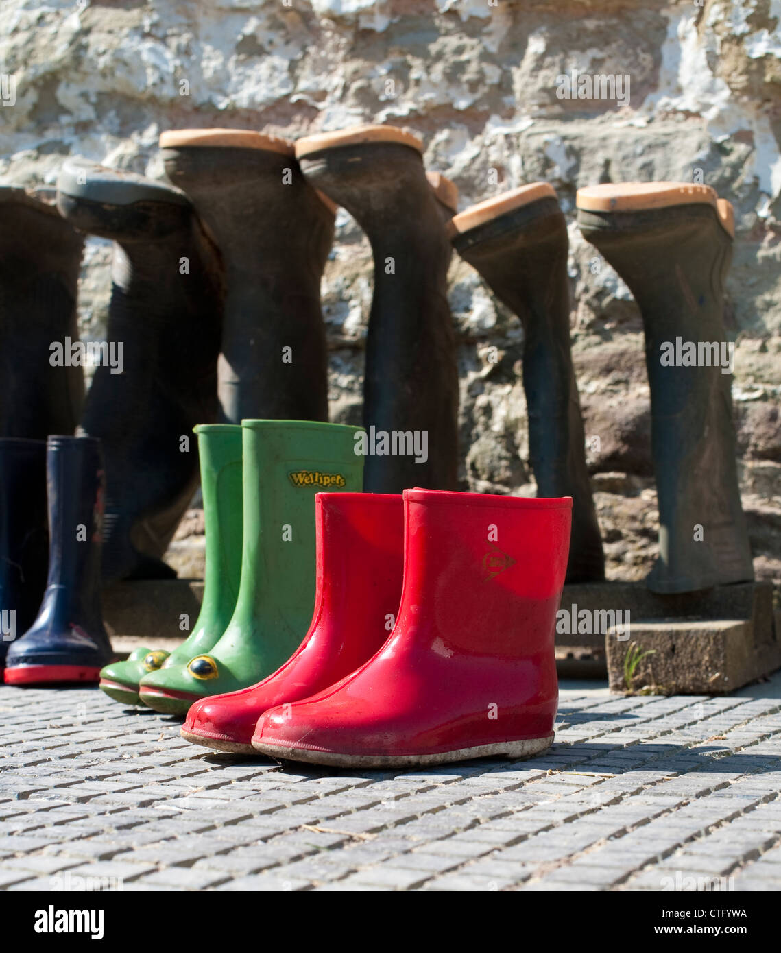 Paare von Erwachsenen und Kinder Gummistiefel auf einem Bauernhof in Shropshire, England UK Stockfoto