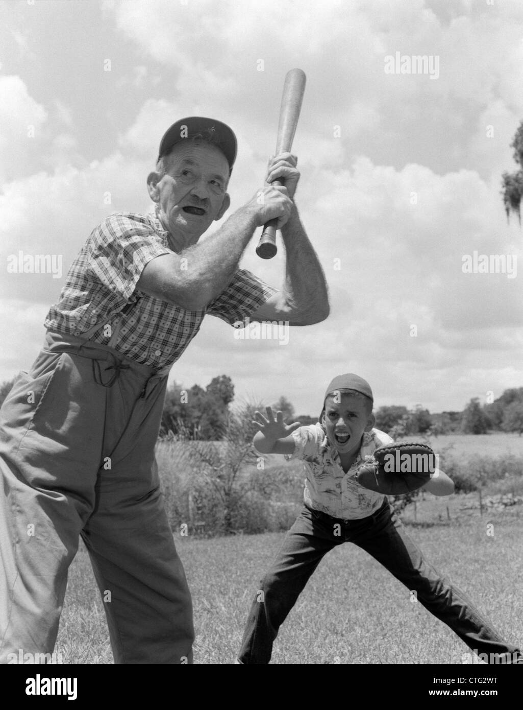 1950ER JAHREN GROßVATER BEI BAT BOY ALS CATCHER SPIELT BASEBALL Stockfoto