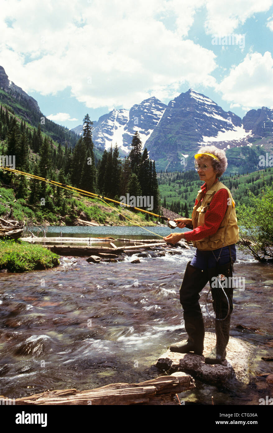 1990ER JAHRE REIFE FRAU FLY FISHING BERGBACH Stockfoto