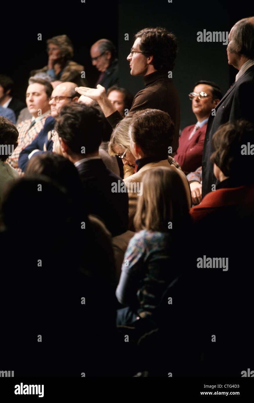 1970ER JAHRE STUDIO FERNSEHPUBLIKUM MIT MANN STEHEND FRAGEN FRAGE Stockfoto
