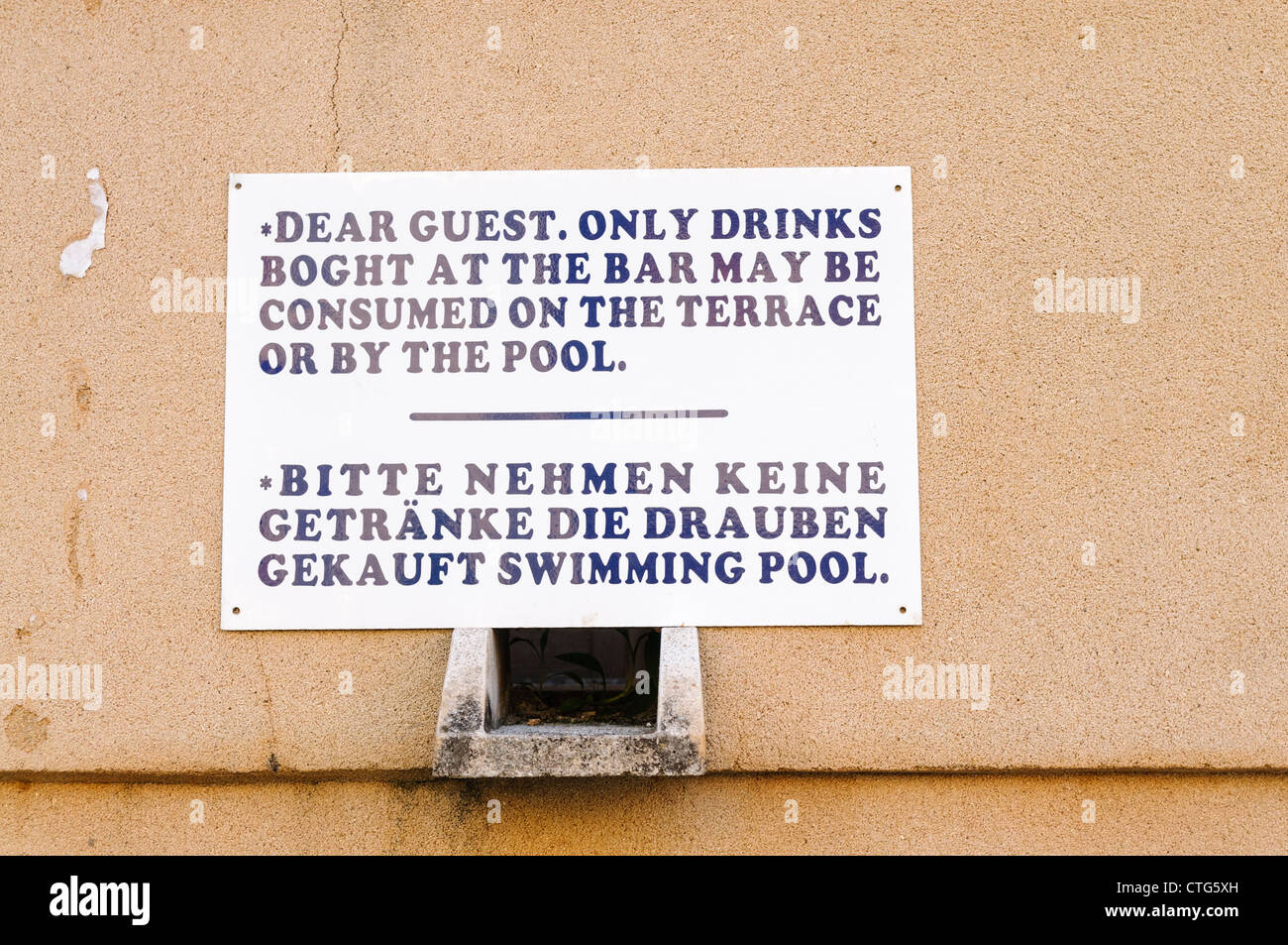 Zweisprachige Zeichen in englischer und deutscher Warnung-Gäste, die nur Alkohol an der Bar gekauft können genutzt werden Stockfoto