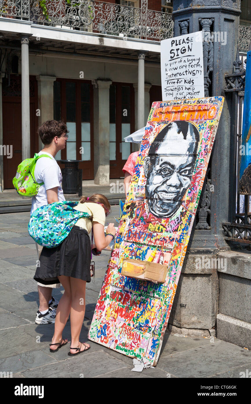 Teenager Frau unterzeichnet interaktive Kunst Malerei im French Quarter von New Orleans, LA Stockfoto