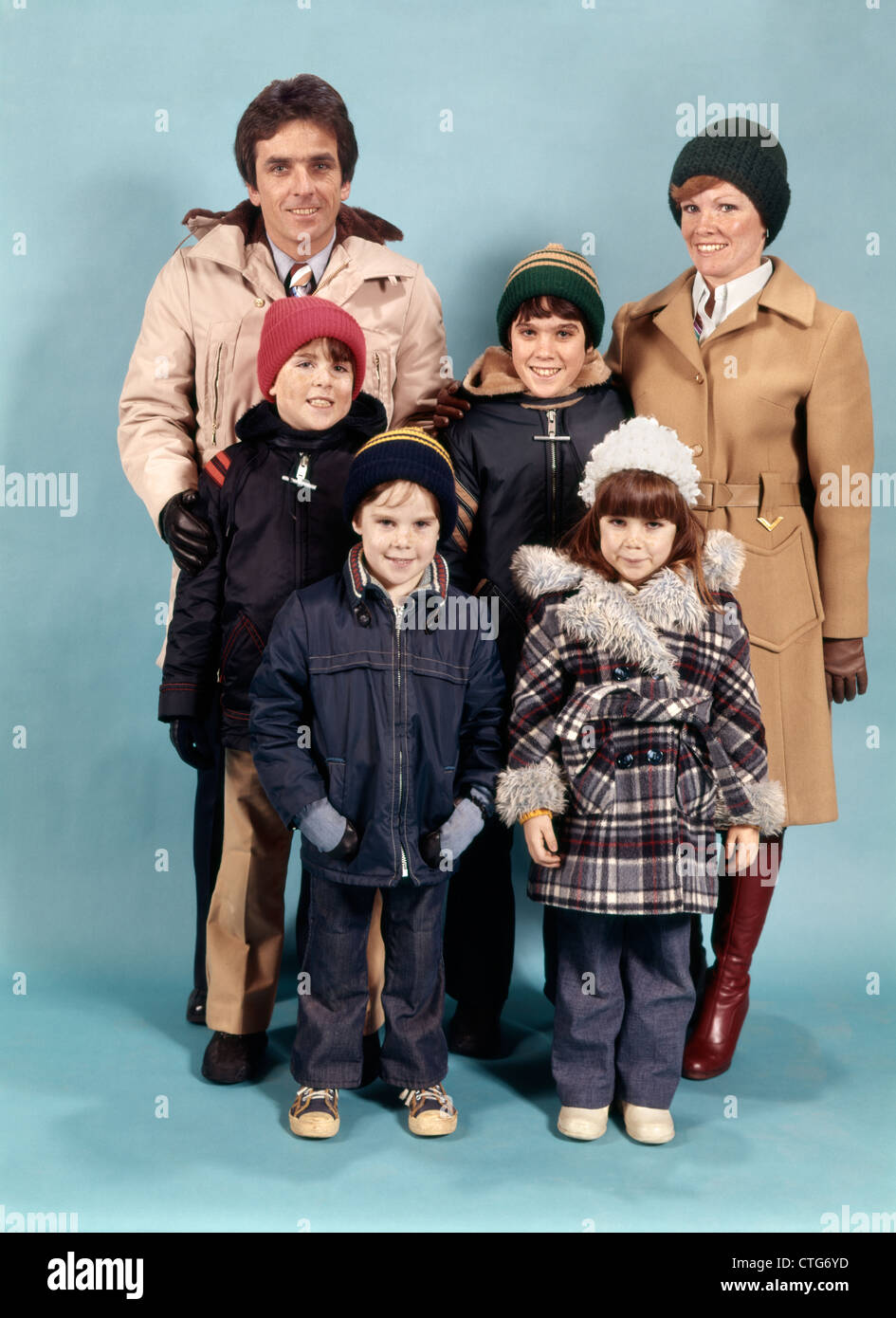 1970ER JAHRE FAMILIE VON SECHS PORTRAIT VOLLER LÄNGE TRAGEN WINTERMÄNTEL BLICK IN DIE KAMERA Stockfoto