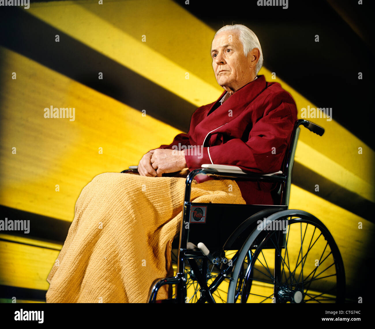 1970ER JAHREN SCHWERE SENIOR ÄLTERE MANN SITZEN ROLLSTUHL Stockfoto