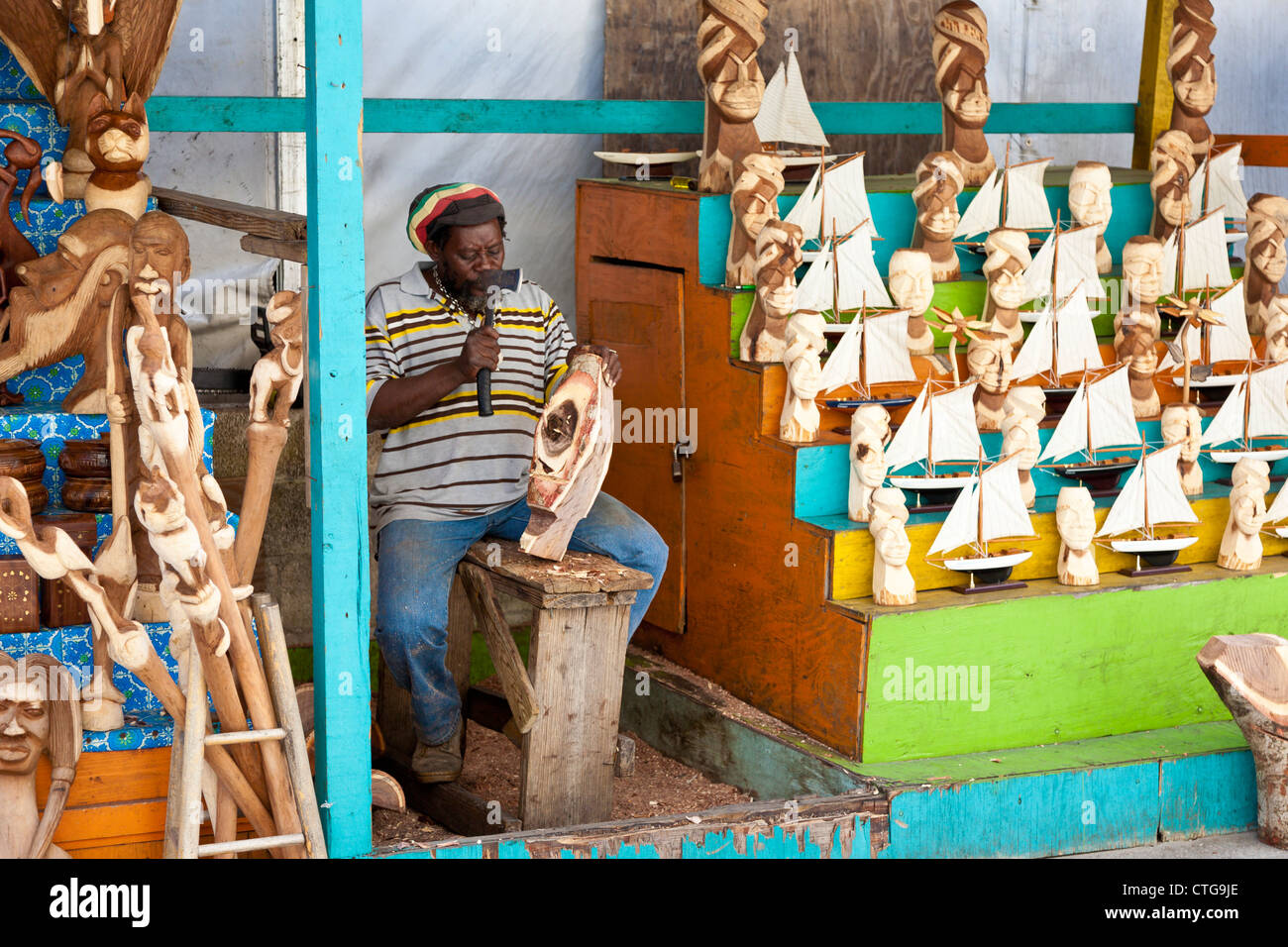 Schwarze Einheimische Bahamian schnitzt aus Holz Geschenke und Souvenirs auf dem Stroh Markt in Nassau, Bahamas Stockfoto