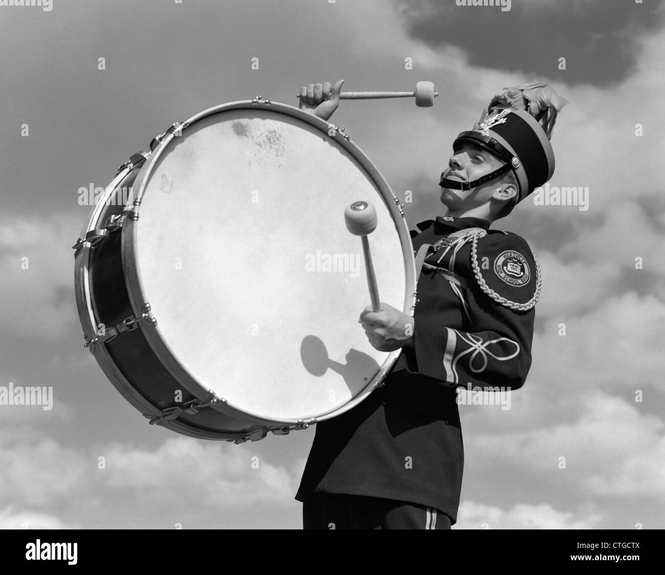 1950ER JAHRE PORTRAIT EINES JUNGEN IN BAND EINHEITLICHE SPIELEN GROßE TROMMEL Stockfoto