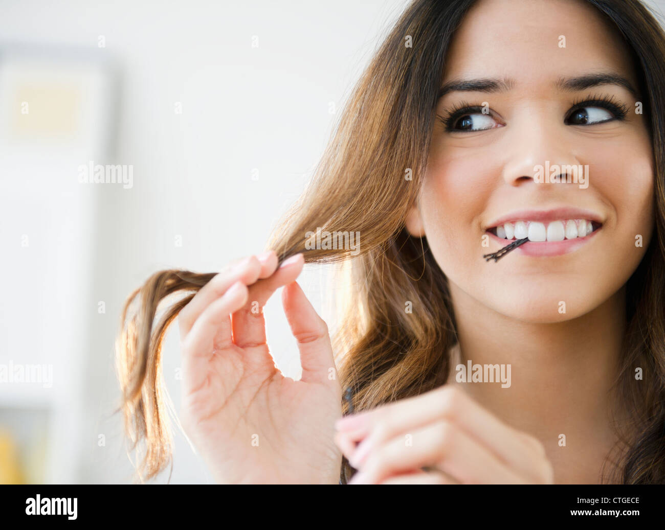 Hispanic Frau mit Bobby Pins in den Mund Stockfoto