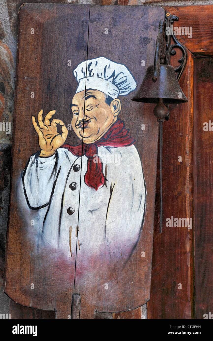 Eine hölzerne Pizzaschieber mit einem Koch, gemalt in einem Restaurant in  Bran, Siebenbürgen, Rumänien Stockfotografie - Alamy