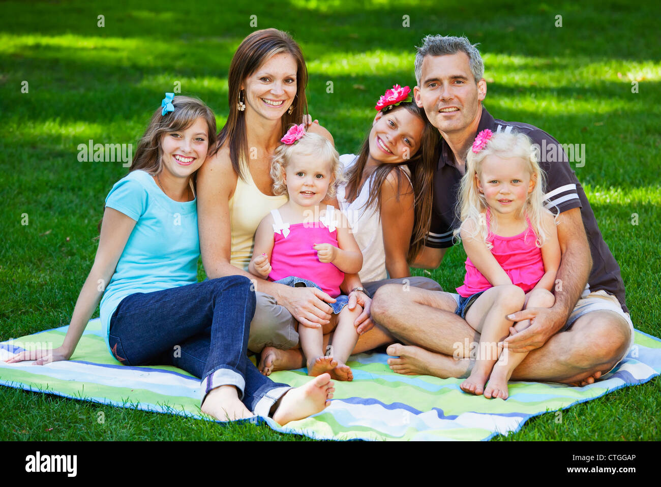 Porträt einer Familie im Park auf einer Decke; Edmonton, Alberta, Kanada Stockfoto