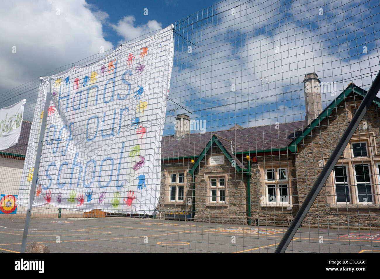 "Hände weg von unserer Schule" handgemaltes Schild mit Kinder-Handabdrücke außerhalb Whitton Grundschule Powys Mid Wales UK Stockfoto