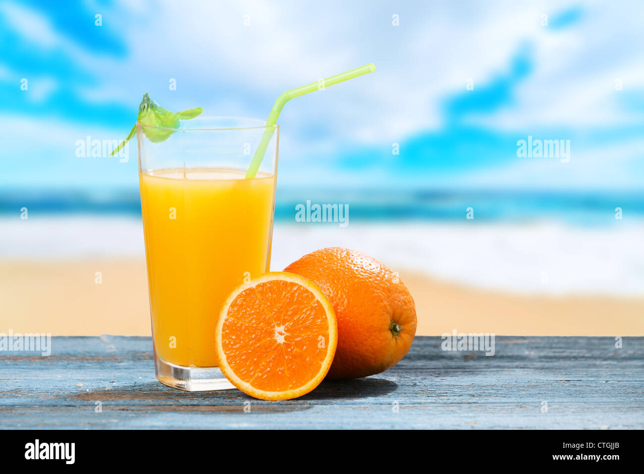 Glas Orangensaft und Meer im Hintergrund Stockfoto