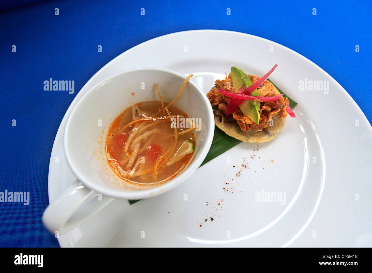 Kalk-Suppe mit Huhn, Tomaten und Tortilla-Streifen. Zusammen mit gebackenen Bohnen auf einem Mais-Tortilla. Ein Gericht, Yucatan. Stockfoto