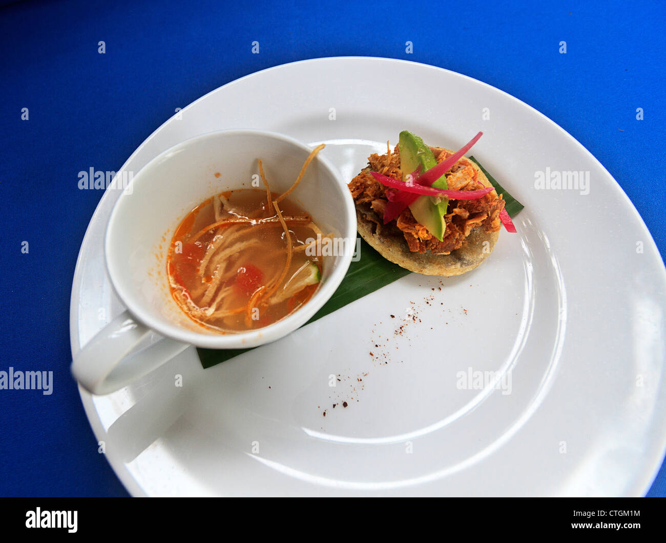 Kalk-Suppe mit Huhn, Tomaten und Tortilla-Streifen. Zusammen mit gebackenen Bohnen auf einem Mais-Tortilla. Ein Gericht, Yucatan. Stockfoto