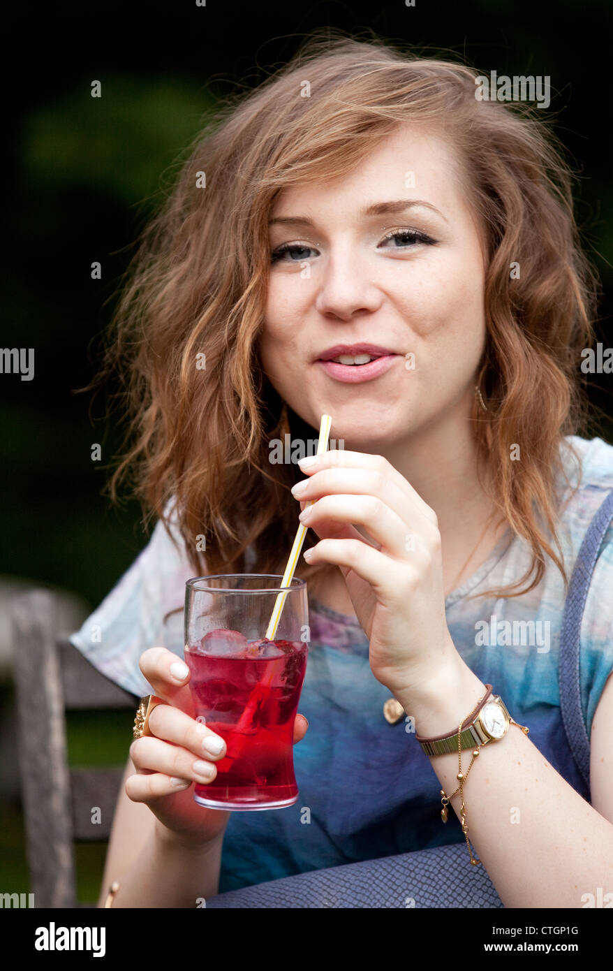 Attraktive junge Frau, die einen Cocktail zu trinken, auf einer Party, UK Stockfoto