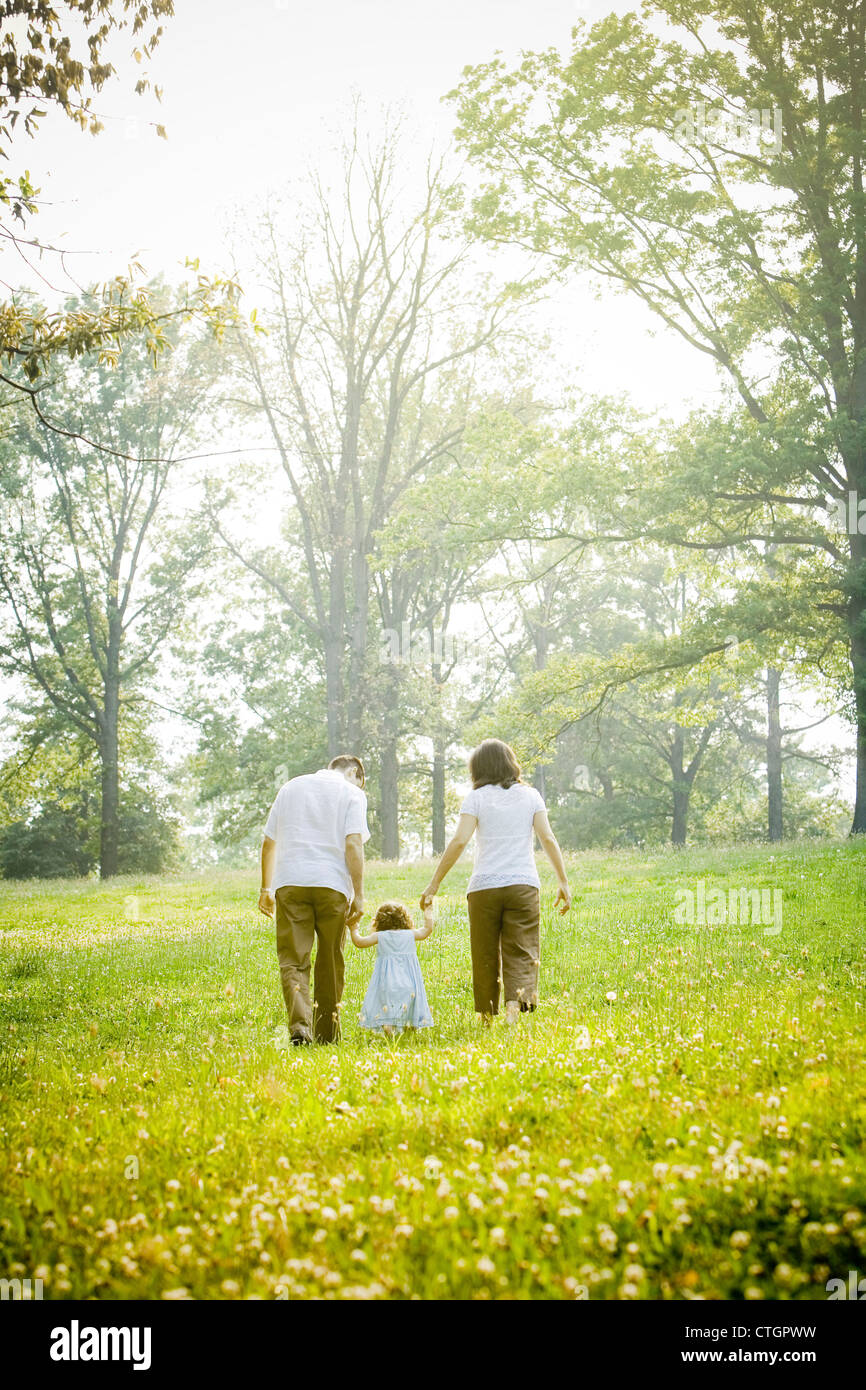 Eltern gehen mit Tochter im Feld Stockfoto