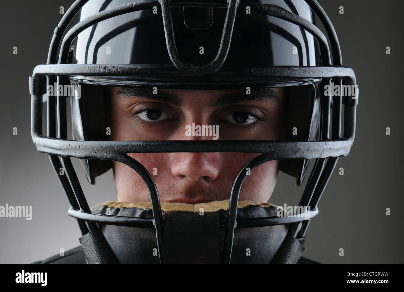 Nahaufnahme von einer männlichen Baseball-Catcher mit seinem Schutzmaske auf. Querformat mit einer leichten bis dunkelgrauen Hintergrund. Stockfoto