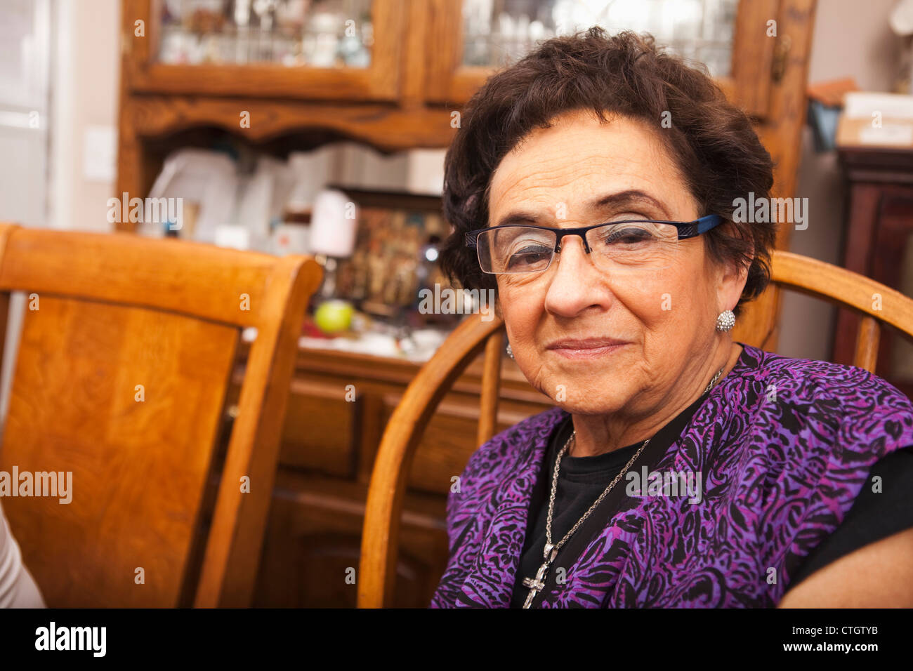 Senior-Hispanic Frau am Tisch Stockfoto