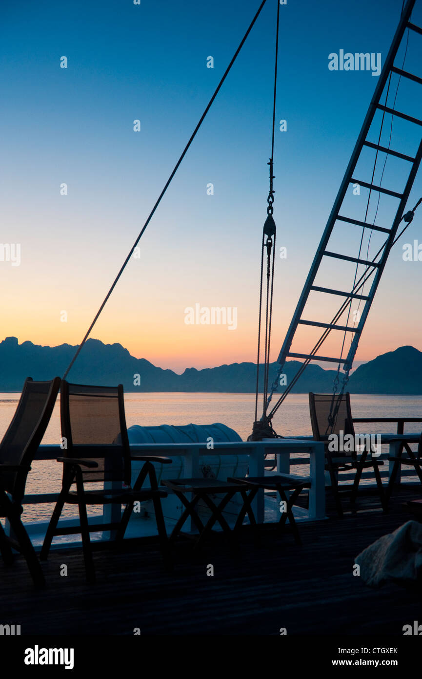 Die Insel Komodo ist an Bord der "Ombak Putih" eine traditionelle Pinisi-Schoner aus Holz bei Sonnenaufgang im Hintergrund zu sehen. Stockfoto