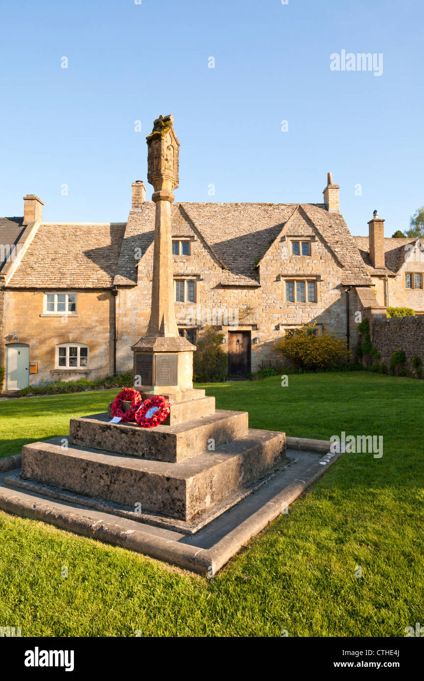 Abend-Sonnenlicht fällt auf das Kriegerdenkmal und Hütten in den Cotswold Dorf Guiting Power, Gloucestershire Stockfoto