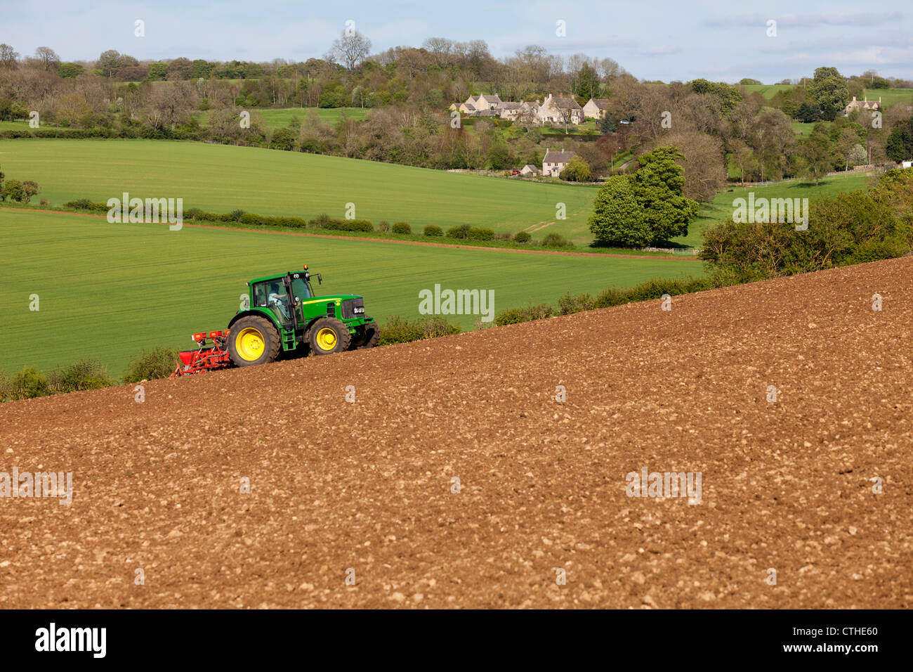 Ein Traktor und Saatgut Bohrer Aussaat auf Cotswold frech Boden in der Nähe der Cotswold-Dorf Hampen, Gloucestershire Stockfoto