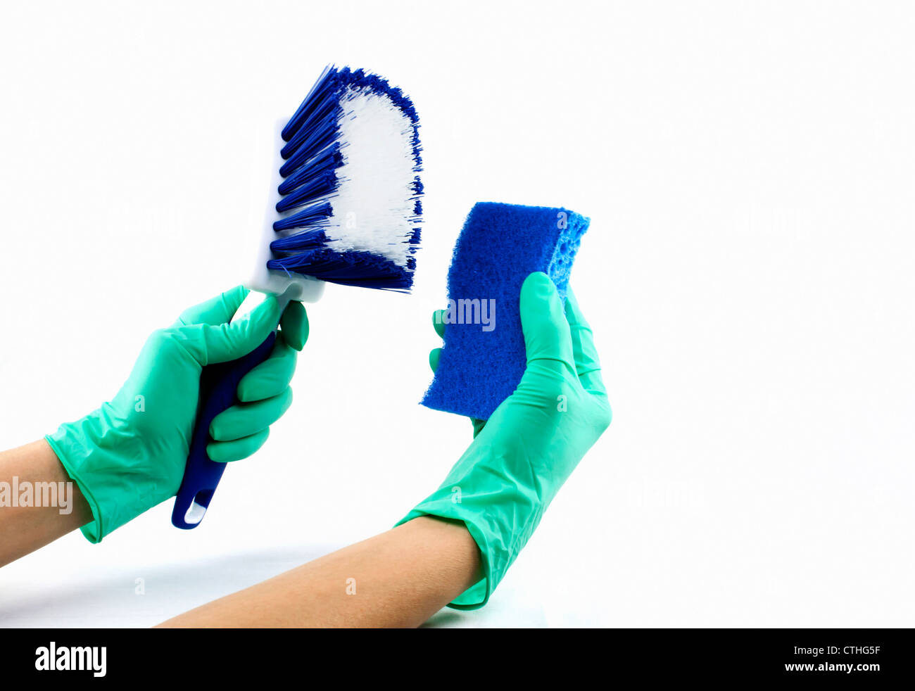 Hände mit grünen Gummihandschuhen hält einen blauen Schwamm und Hausreinigung Scheuerbürste isoliert auf weißem Hintergrund. Stockfoto