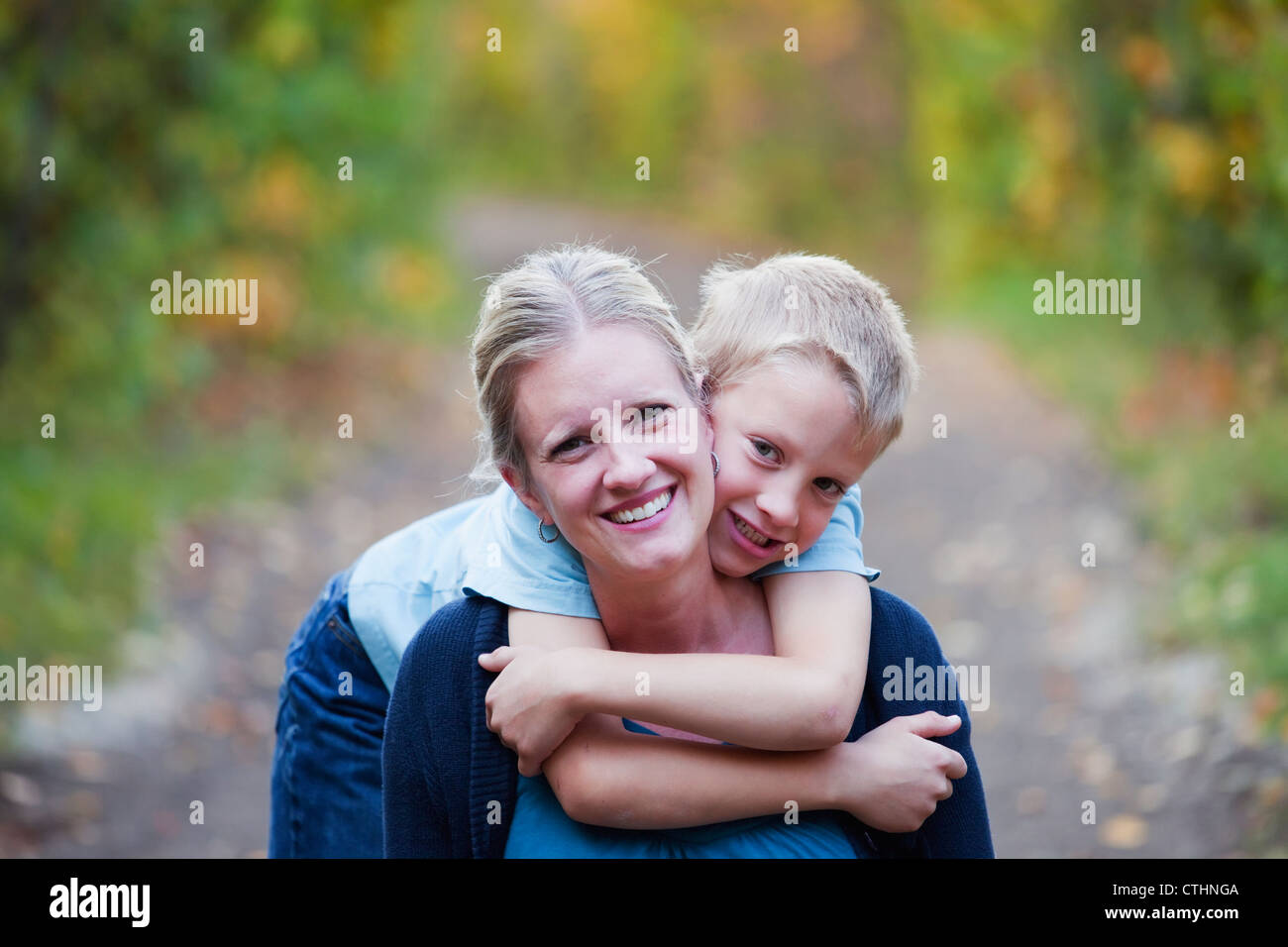 Kleiner Junge umarmt seine Mutter auf einem Park-Weg im Herbst; Edmonton, Alberta, Kanada Stockfoto