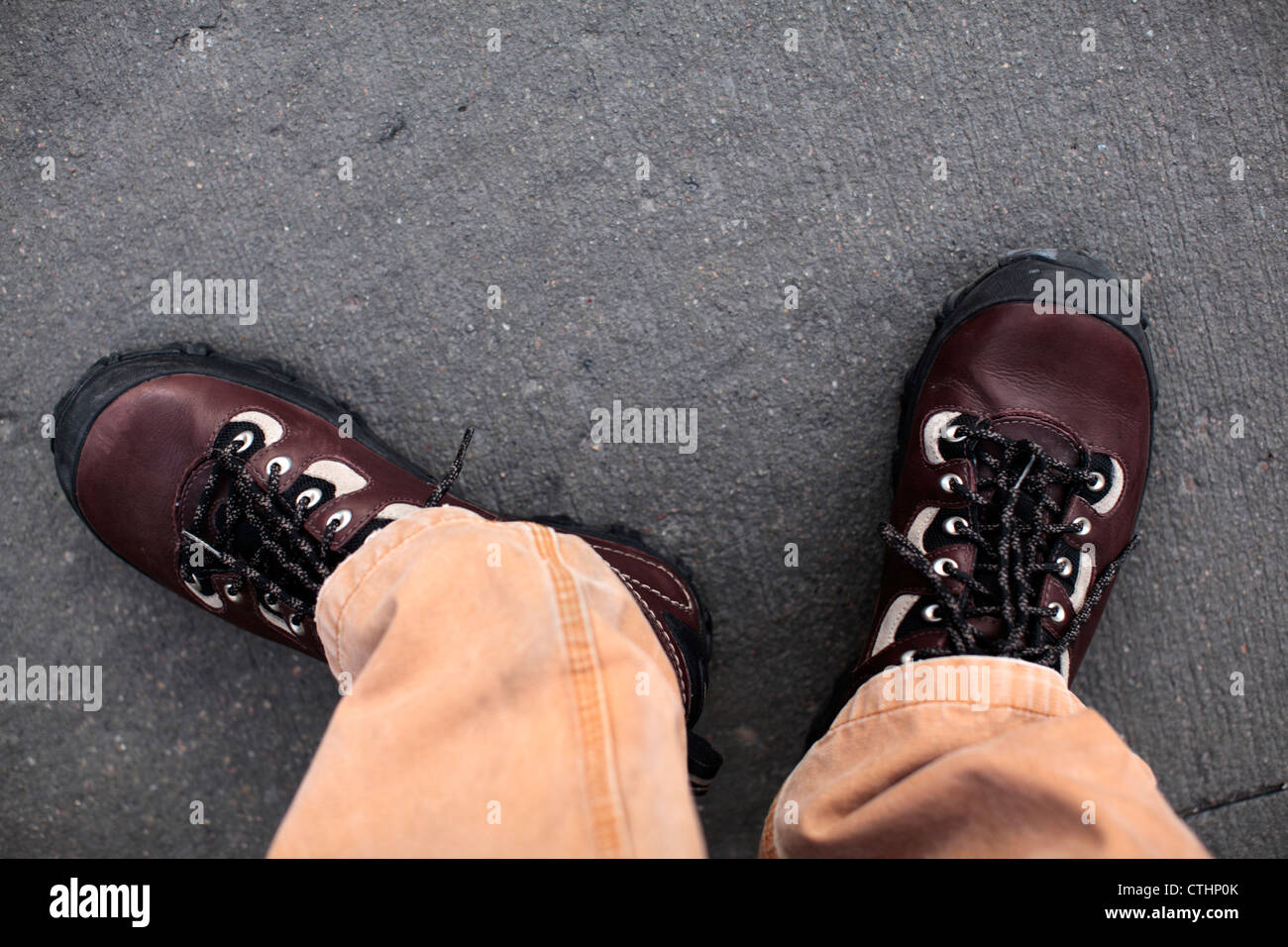 Männliche Füße tragen braune Lederschuhe Patagonia Drifter und Canvas Khaki Hosen. Stockfoto