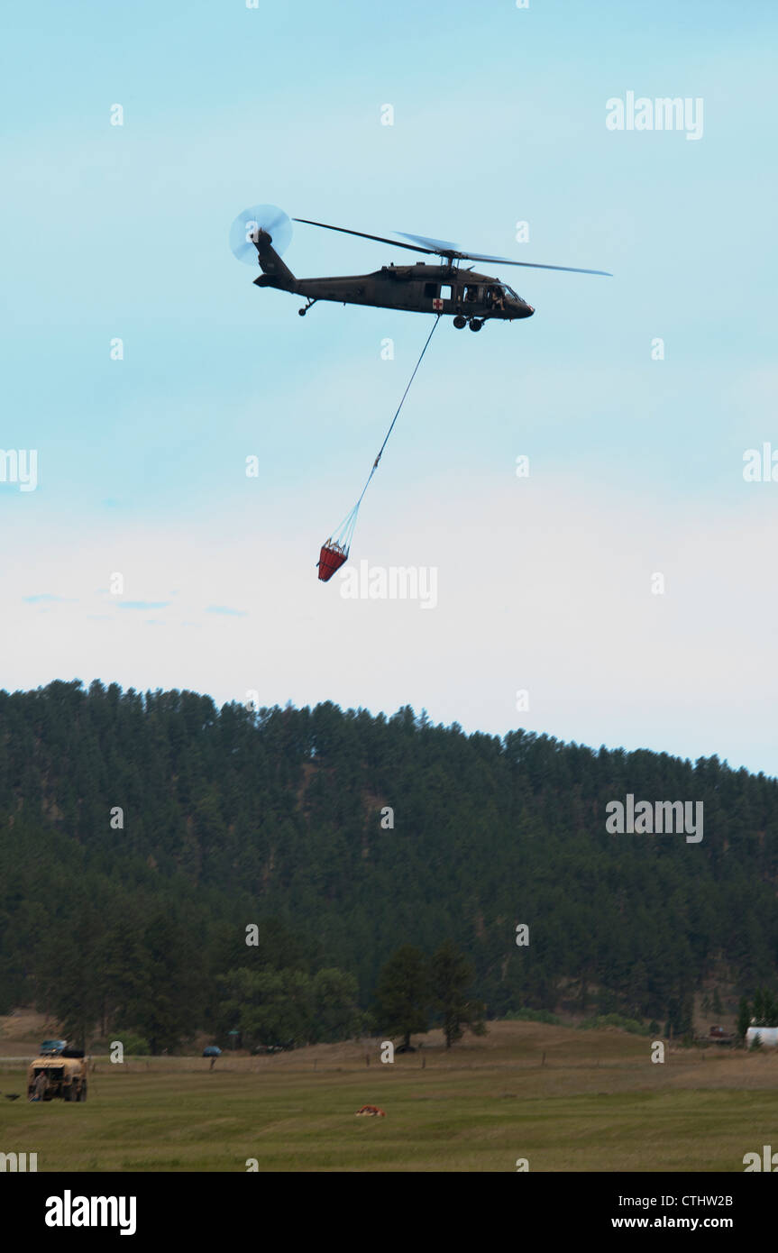 Ein South Dakota Army National Guard UH-60 Black Hawk führt Wasser - Schaufel drop Operationen zu helfen, enthalten die 7.000 Morgen Myrtle Feuer, das sich ca. 1,6 km südlich von Pringle, S.D. Stockfoto