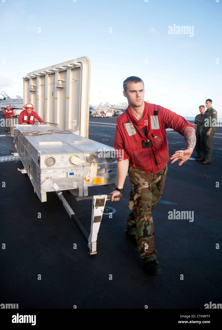 Flugverordnanceman die Piloten Jonathan Cline aus Blairsville, Ga., Front, und Josiah Sater aus Decatur, Abb., bewegen Kisten mit Bordmitteln über das Flugdeck des Flugzeugträgers USS George Washington (CVN 73). George Washington, der einzige nach vorne eingesetzte Flugzeugträger der Marine, entwich Fleet Aktivitäten Yokosuka ist auf seiner Patrouille 2012. Stockfoto