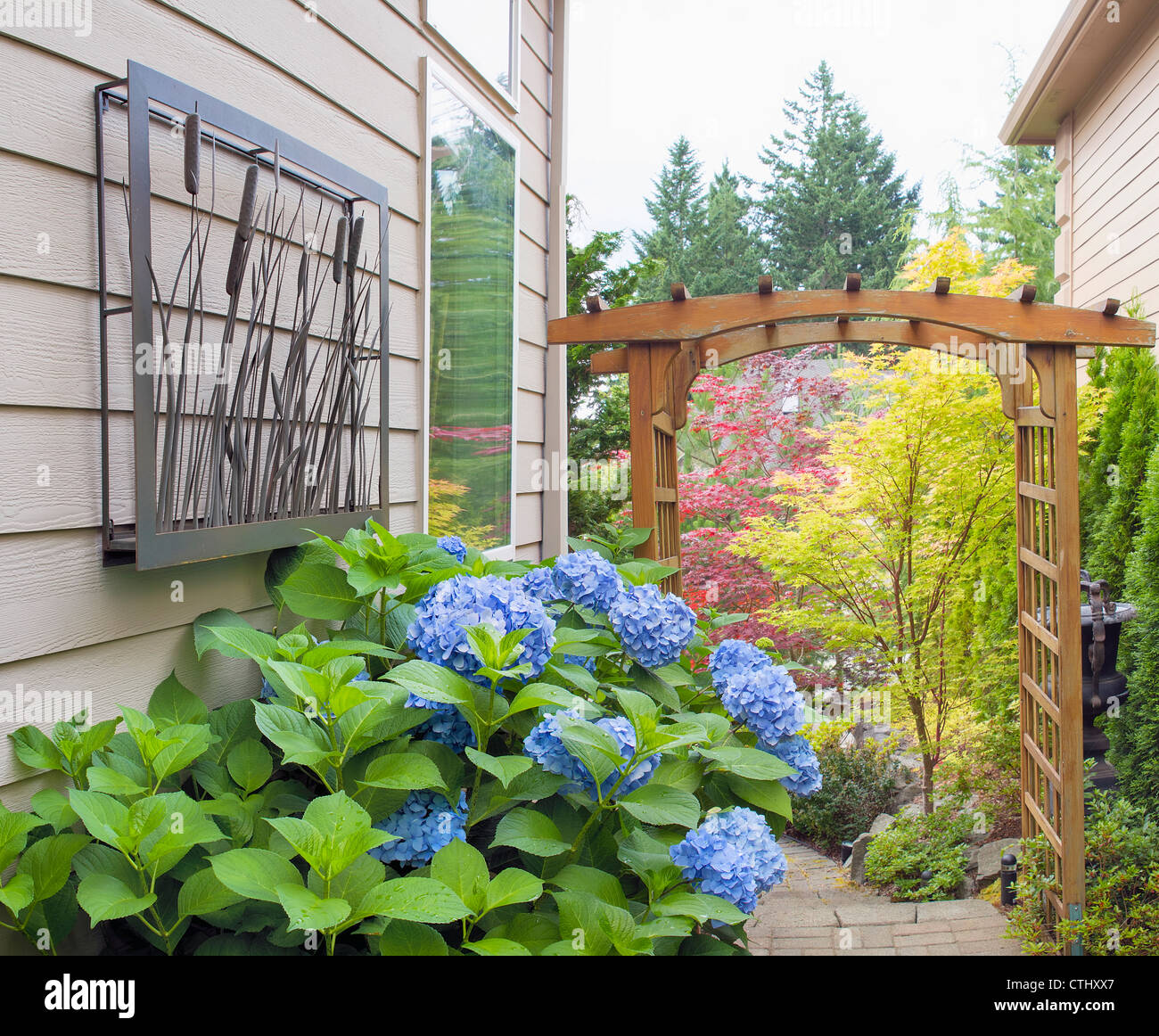 Garten Eingang mit hölzernen Arbor Steinstufen Metall-Dekoration und  Pflanzen Stockfotografie - Alamy