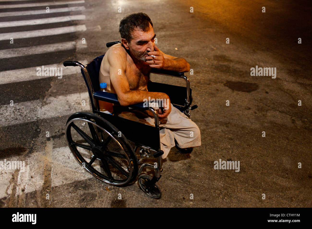 Person mit Behinderung sitzt im Rollstuhl auf der Straße in Tel Aviv Israel Stockfoto