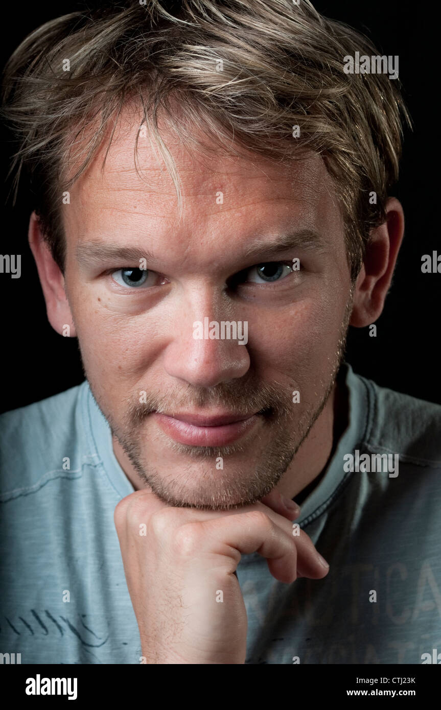 Junger Mann stützte sich auf seine hand Stockfoto
