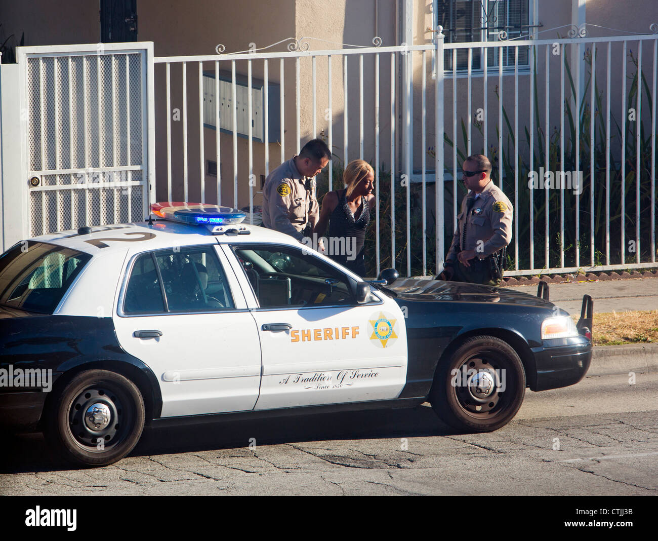 Inglewood, Kalifornien - Los Angeles County Sheriff Stellvertreter Verhaftung eine Frau auf der Straße. Stockfoto