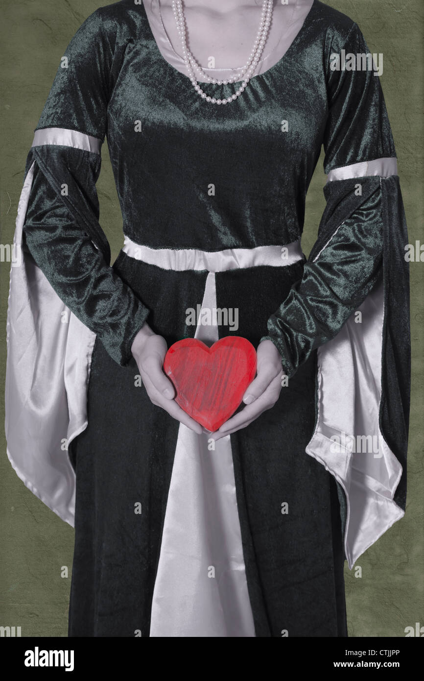 eine Frau in einem viktorianischen Kleid ein Herz in ihren Händen hält Stockfoto