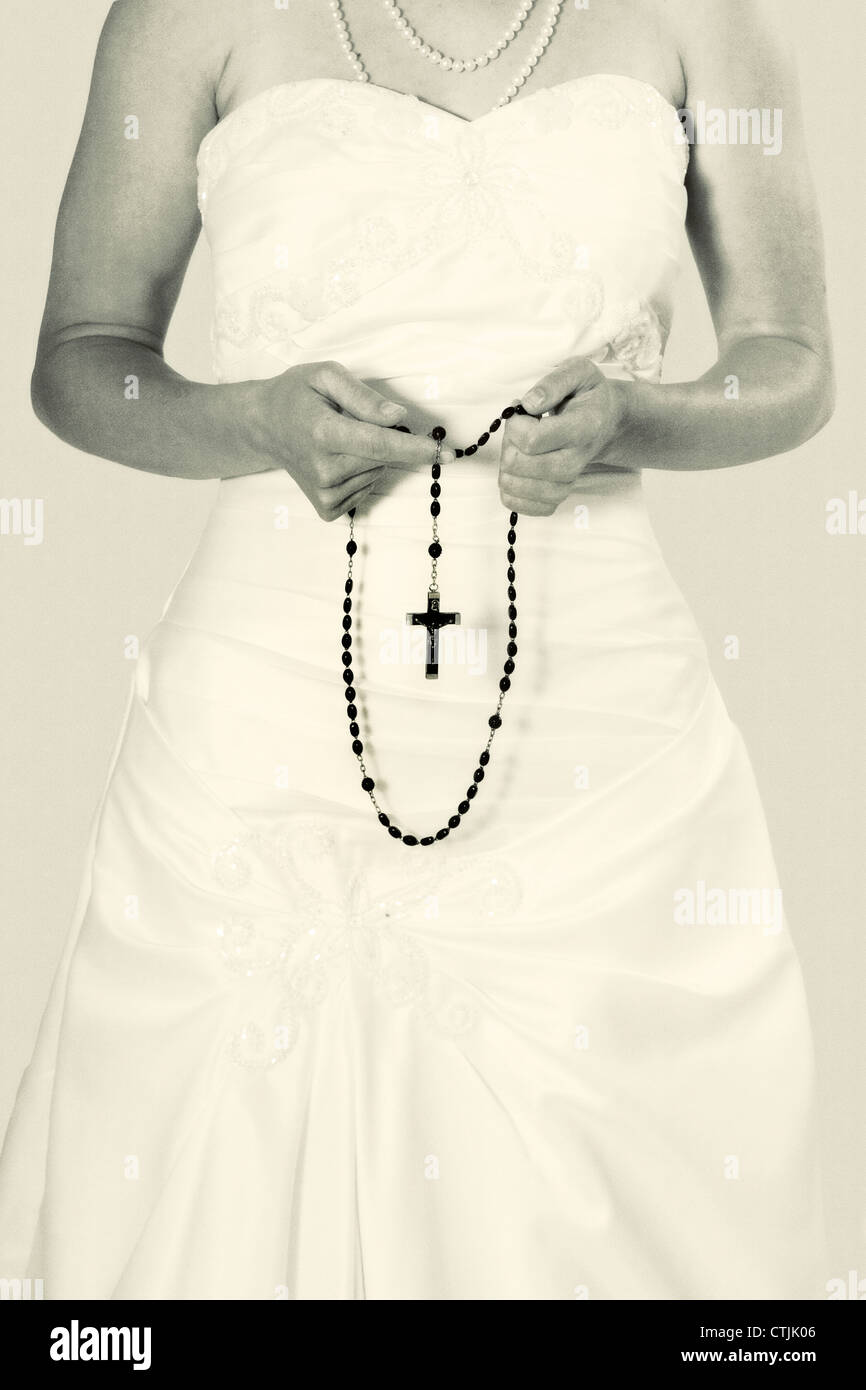 eine Frau hält einen Rosenkranz in den Händen Stockfoto