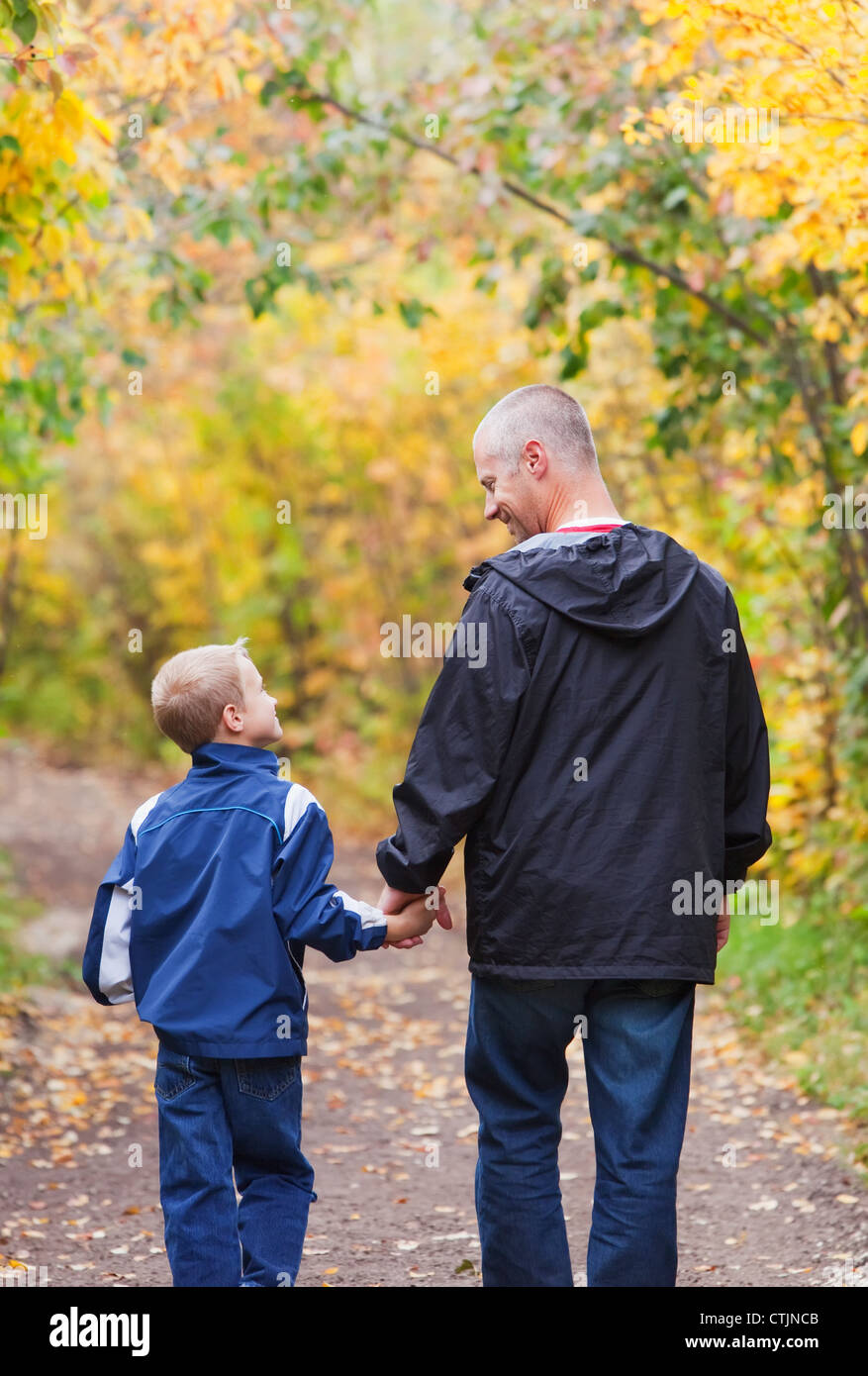 Vater und Sohn zu Fuß auf einem Pfad In einem Park im Herbst; Edmonton, Alberta, Kanada Stockfoto