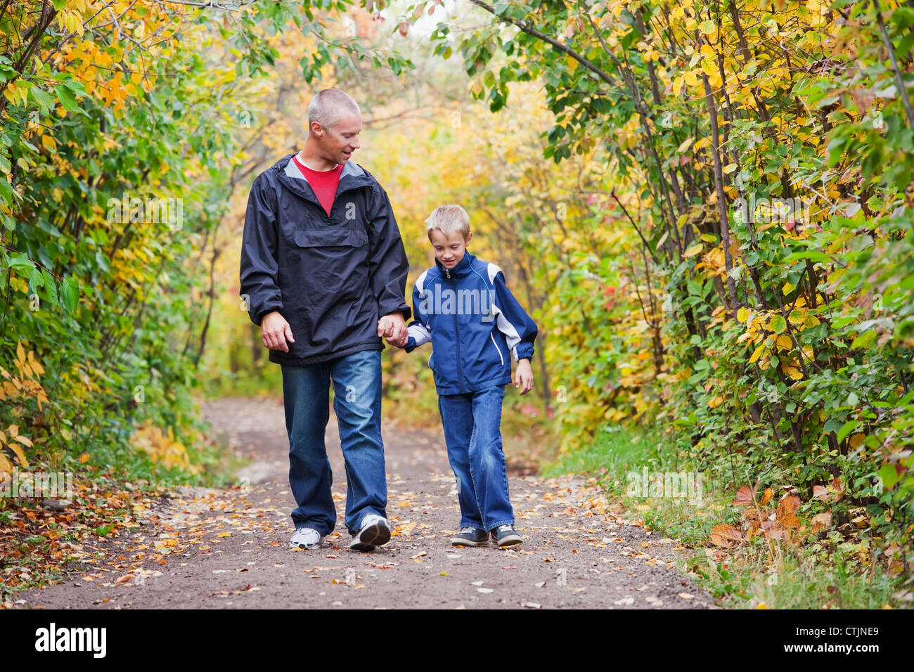 Vater und Sohn zu Fuß auf einem Pfad In einem Park im Herbst; Edmonton, Alberta, Kanada Stockfoto
