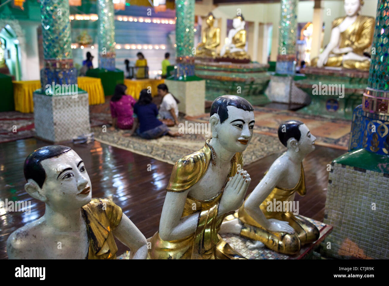 Statuen von buddhistischen Mönchen in der Nacht in einer der Hallen der Shwedagon-Pagode in Yangon (Rangoon), Myanmar (Burma) Stockfoto