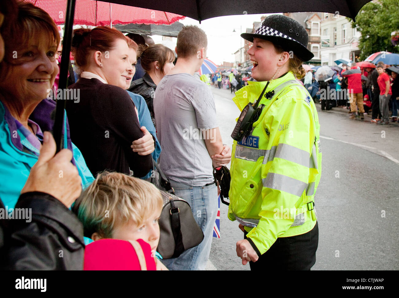 Fröhliche Polizistin im Gespräch mit der Öffentlichkeit, UK Stockfoto