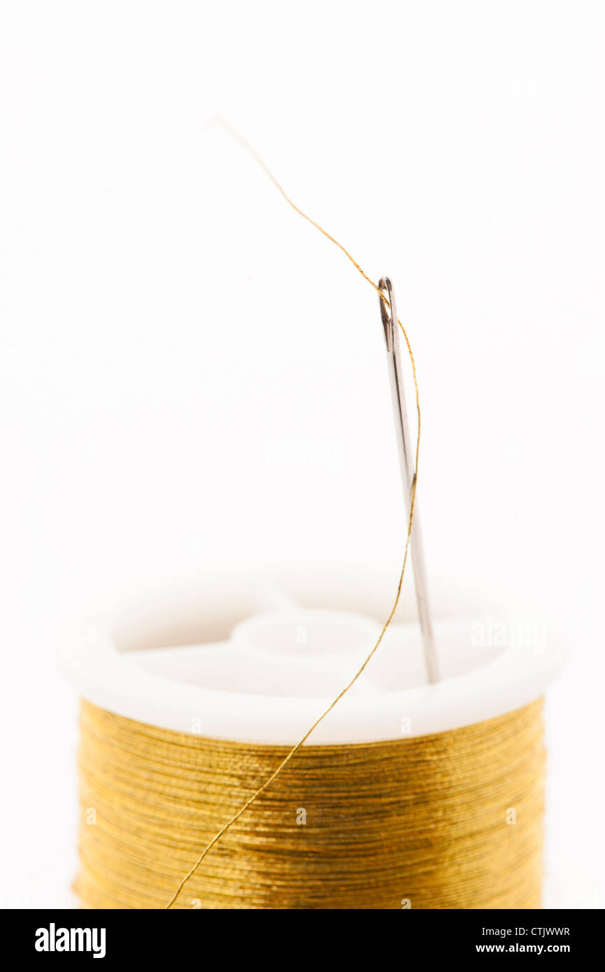 Thread Needle und Spool-gold metallic Nähgarn Stockfoto