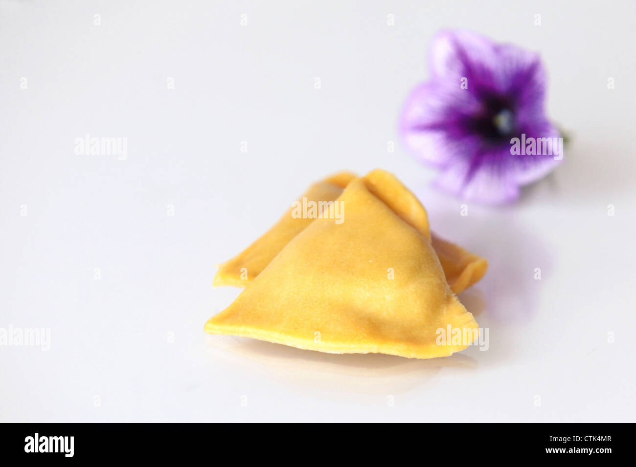 Frische ungekochte Ravioli (gefüllte Nudeln) auf weißem Hintergrund Stockfoto