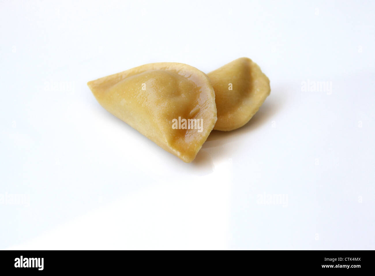 Frische ungekochte Ravioli (gefüllte Nudeln) auf weißem Hintergrund Stockfoto